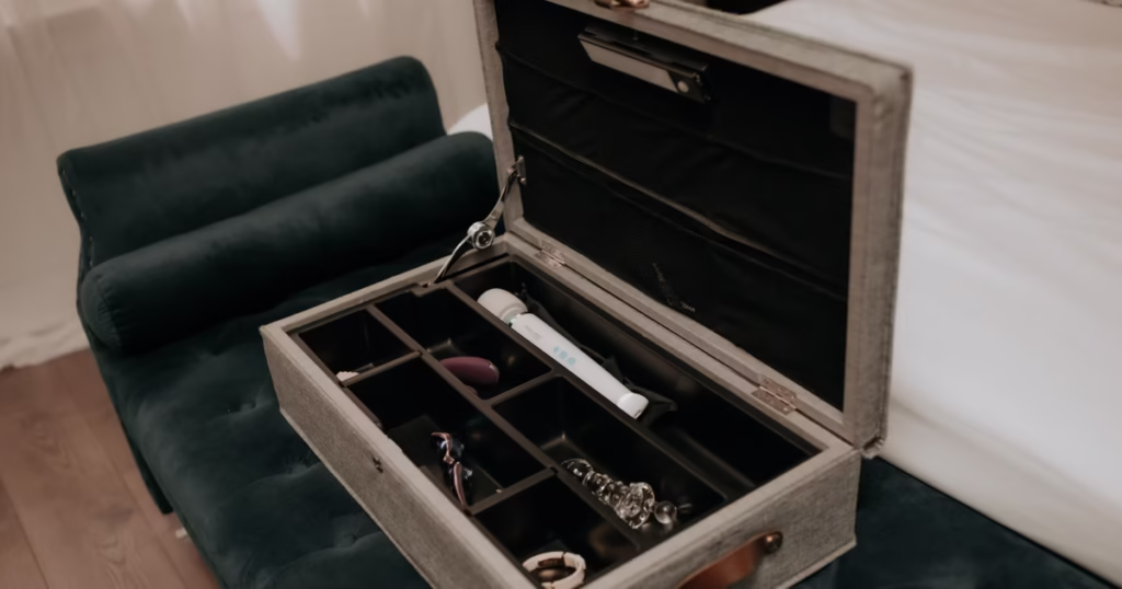 The KinkBox under-bed box open showing organized sex toys.